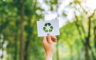 Fundo de árvores com uma imagem de reciclagem representando o E de ESG.
